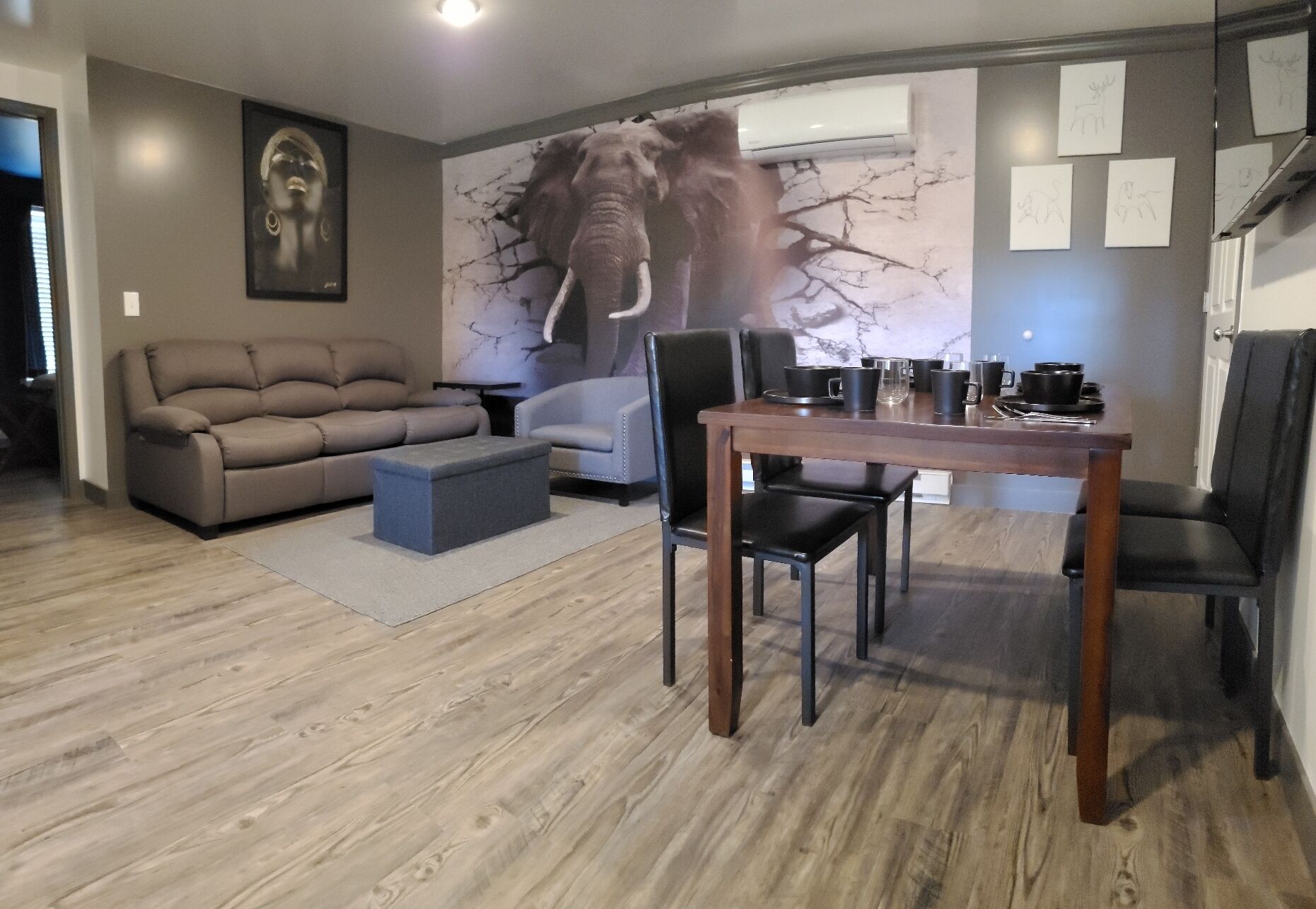 A modern living room with a sofa, a coffee table, and a dining table with chairs.