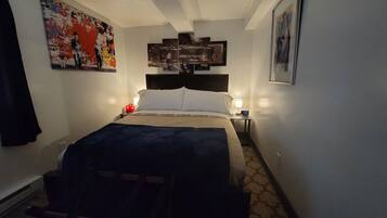 Een hotelkamer met een bed, nachtkastjes, een klok en kunstwerken aan de muur.