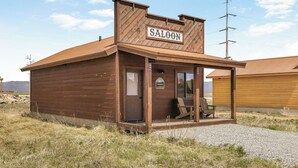 A wooden building with a sign reading 'SALOON' and a small porch area. - Family-Friendly Old West Cabin Near YNP (Island Park)
