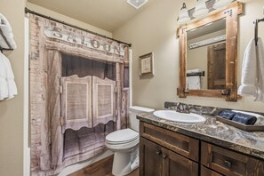 Een bad/douchecombinatie, een haardroger, handdoeken, toiletpapier