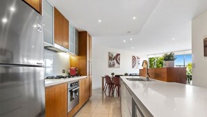 A modern kitchen with stainless steel appliances, wooden cabinets, and a central island.