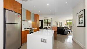 A modern kitchen with a central island, built-in appliances, and a dining area with a view.