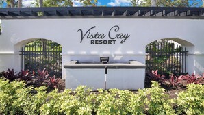 Señal de Vista Cay Resort con entrada vigilada y jardín ajardinado.