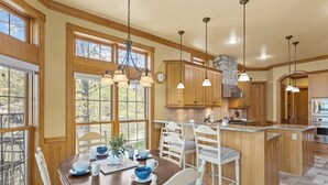 Une cuisine avec des meubles en bois, un îlot central et des luminaires suspendus.