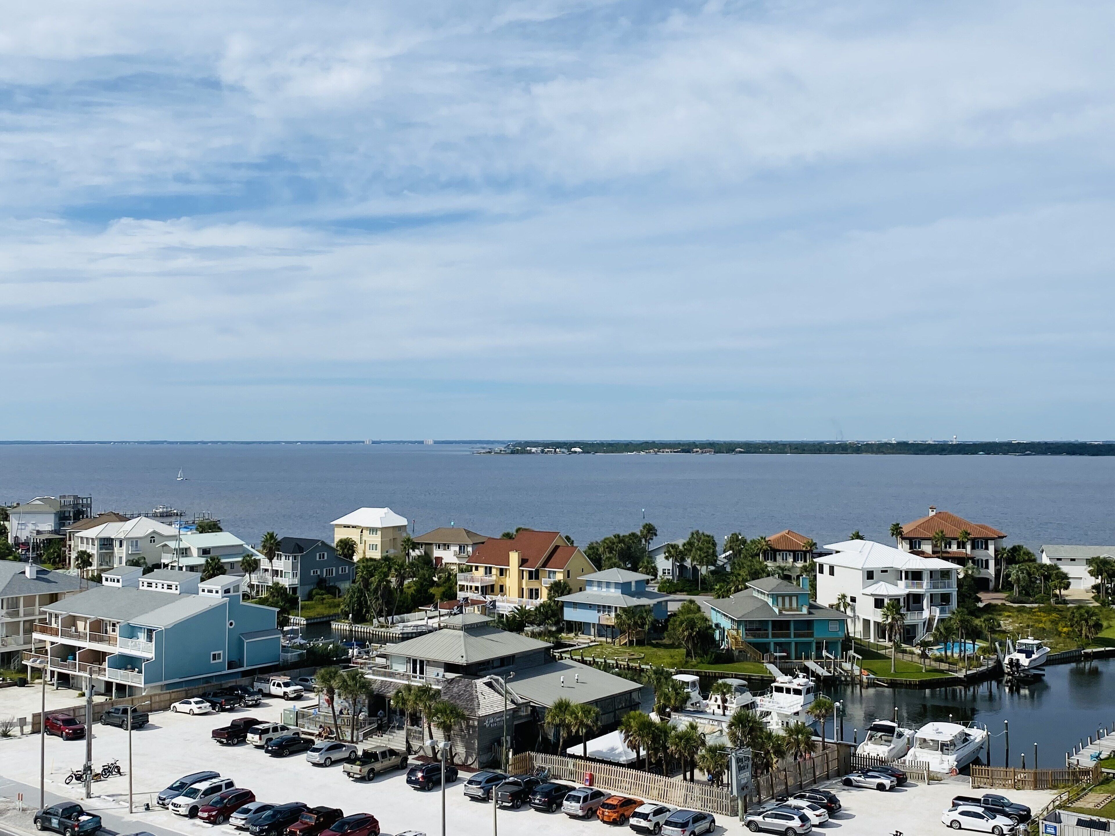 A coastal residential area with houses, a marina, and a view of the sea.
