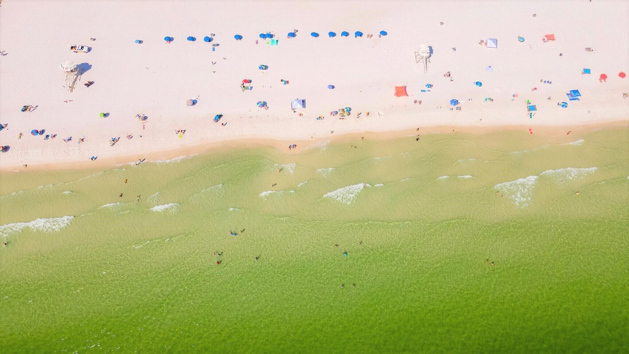 Una playa con gente y sombrillas.