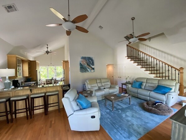 A spacious living area with a kitchen, a dining area, and a staircase. - Pass Christian Waterfront w/ Private HEATED Pool & Beautiful Back Porch (Pass Christian)