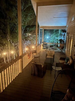 A wooden deck with outdoor furniture, a view of the surrounding trees, and a balcony with a railing. - Pass Christian Waterfront w/ Private HEATED Pool & Beautiful Back Porch (Pass Christian)