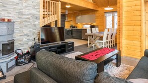 Amplia sala de estar con chimenea, televisor y mesa de comedor con sillas.