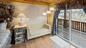 A cozy room with a sofa, a lamp, and a rustic decor including antlers and a vase. - Summer Retreat, Dog Friendly, Fenced Yard, Hot Tub, Game Room, Fire Pit (Flagstaff)