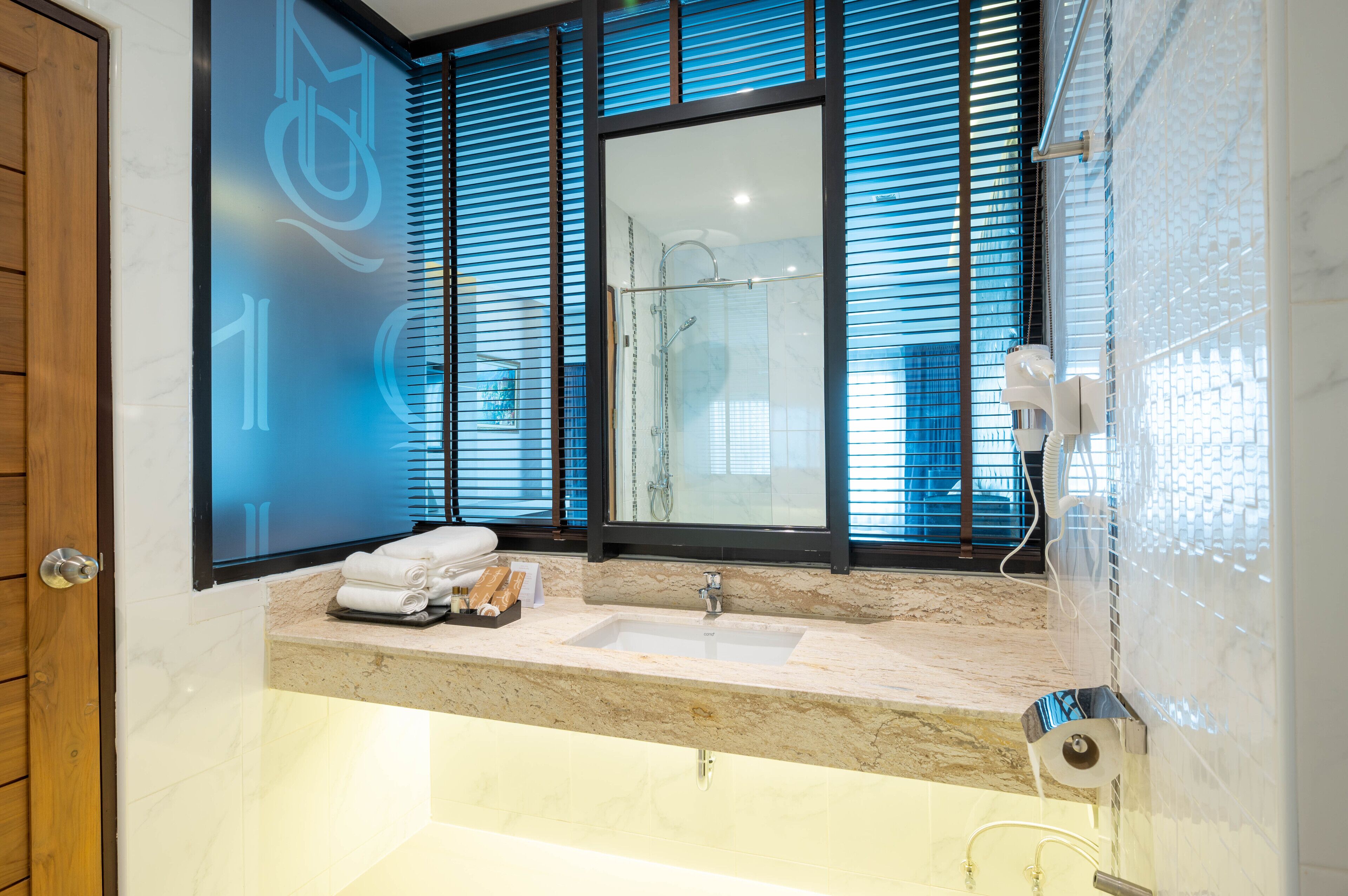 Un baño moderno con un espejo grande, un lavabo y una ducha.