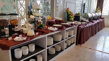 Een buffetopstelling met diverse gerechten en vleeswaren.