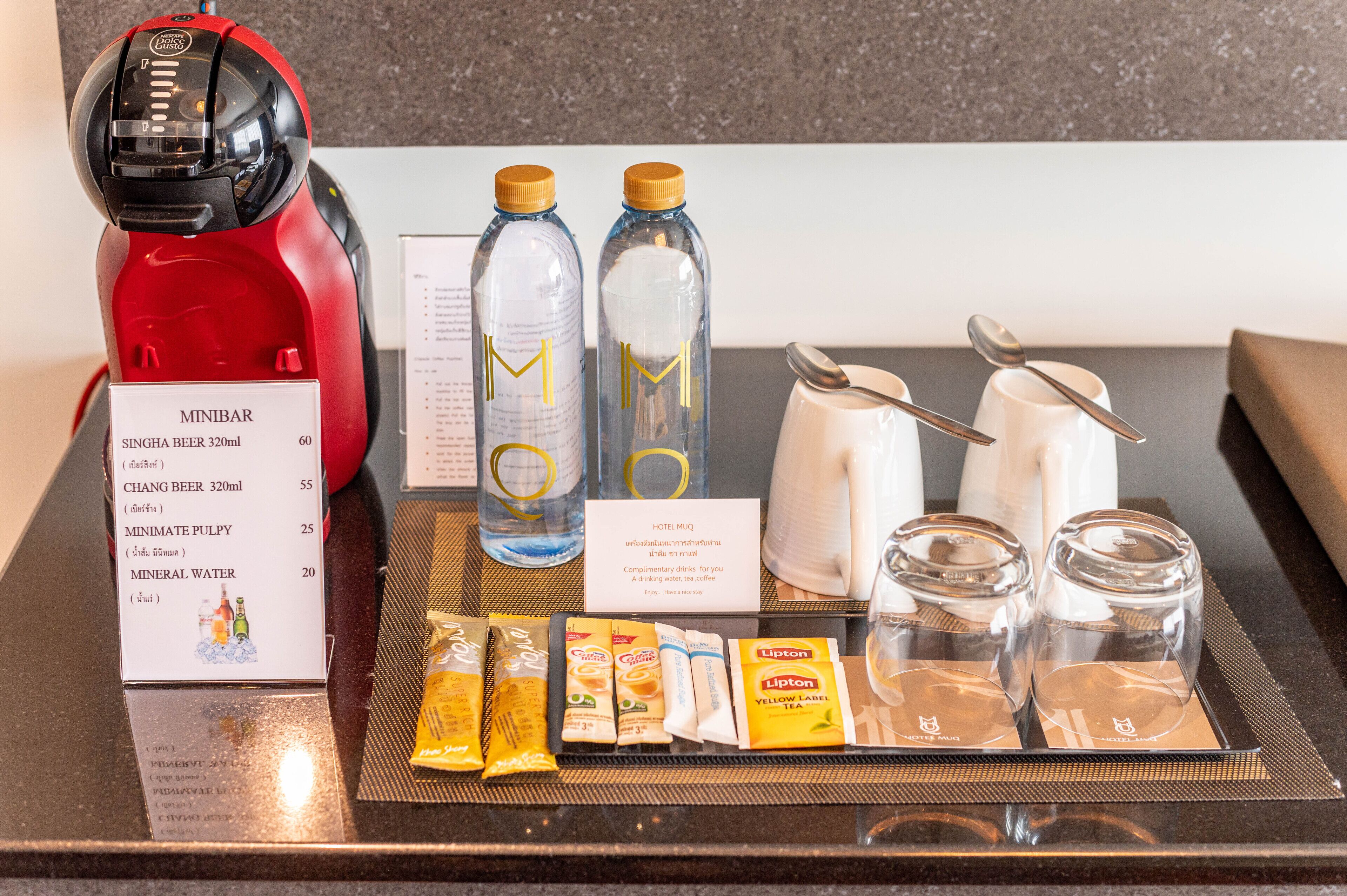 Un minibár con bebidas, aperitivos y una cafetera.