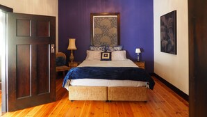 A room with a large bed, a wooden door, a ceiling light, and a framed artwork on the wall. - BALMORAL LODGE  - EXCLUSIVE COUNTRY ESCAPE (Cockatoo Valley)