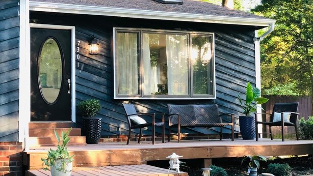 A house with a porch, two chairs, and a potted plant. - Light & airy home w/private hot tub on golf course (Quinton)