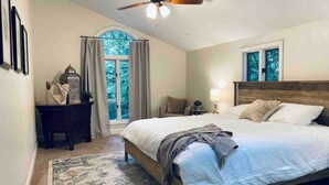 A bedroom with a bed, a ceiling fan, a nightstand, a dresser, and a window with curtains. - Light & airy home w/private hot tub on golf course (Quinton)