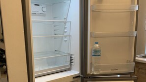 An open refrigerator with multiple shelves and a water dispenser. - Cozy Studio close to seaside and city center (Palaio Faliro)
