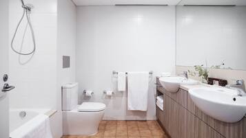 A modern bathroom with a shower, toilet, and sink.
