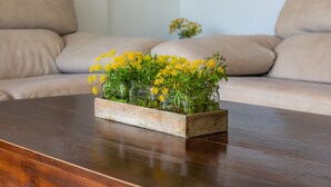 Un bac à fleurs en bois, orné de fleurs jaunes, posé sur une table en bois.