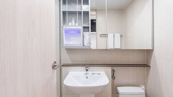 A modern bathroom with a sink, toilet, and a mirror above the sink.