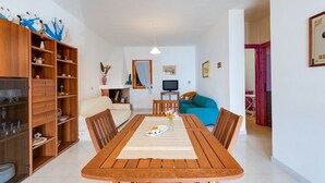 A dining area with a wooden table, chairs, and a buffet cabinet. - Holiday Apartment "La Vista di Mondo" on the Beach with Sea View, Terrace & Garden (Torre dei Corsari Arbus)
