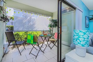 A balcony with a seating area, a table, and a sofa.