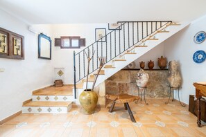 Un escalier avec une rampe en métal, un vase et des objets en céramique sur le palier.