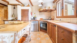A kitchen with wooden cabinets, a built-in oven, and a large window.