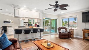 A spacious living area with a leather sofa, a coffee table, and a TV.