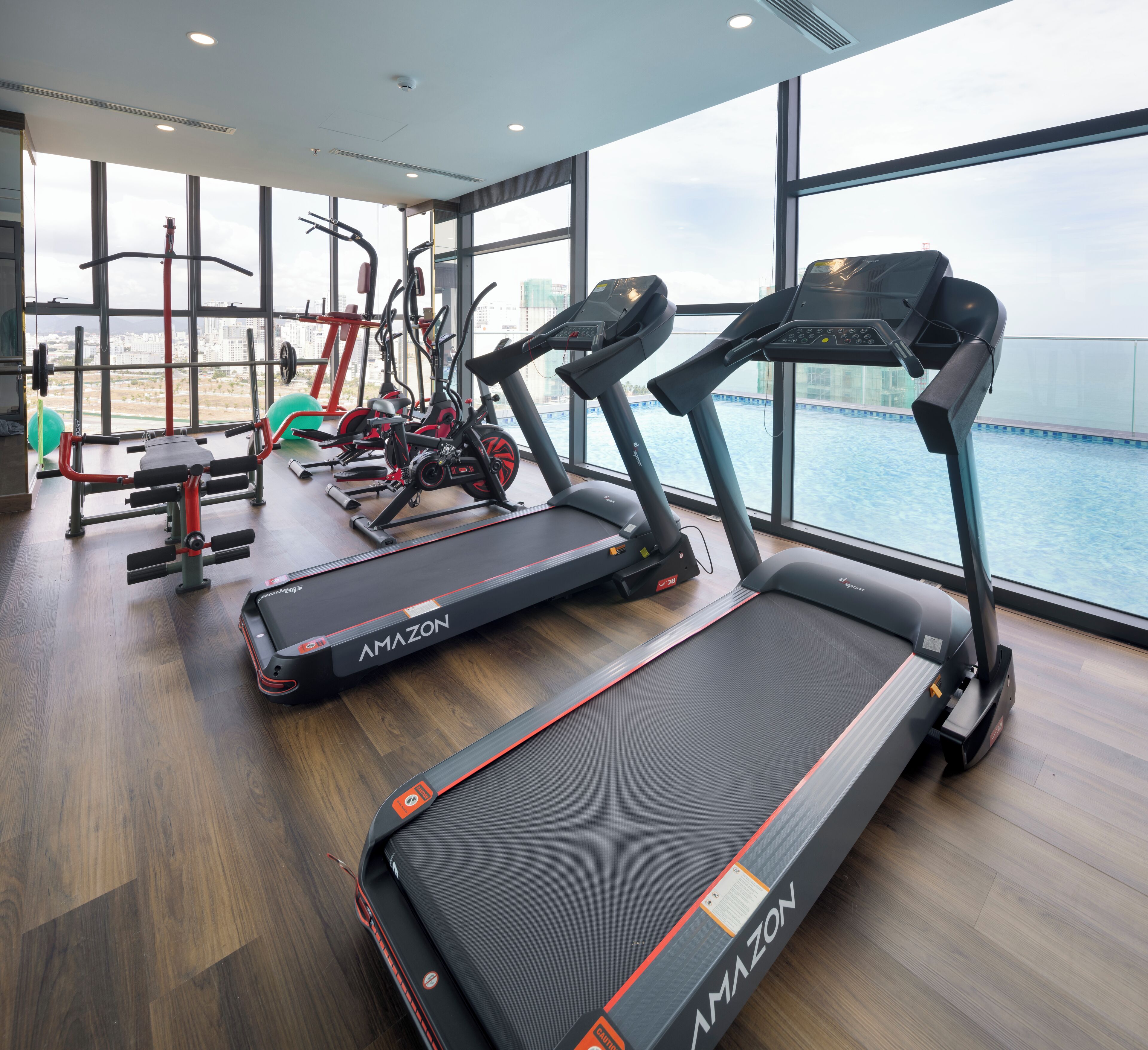 Une salle de sport équipée de tapis de course, de vélos d’appartement et d’appareils de musculation.