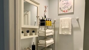Een badkamer met een wastafel, spiegel, handdoekhouder en toiletartikelen.