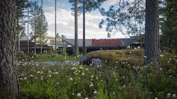 Experience tranquility at Meskellinnens, surrounded by lush vegetation and tall trees.