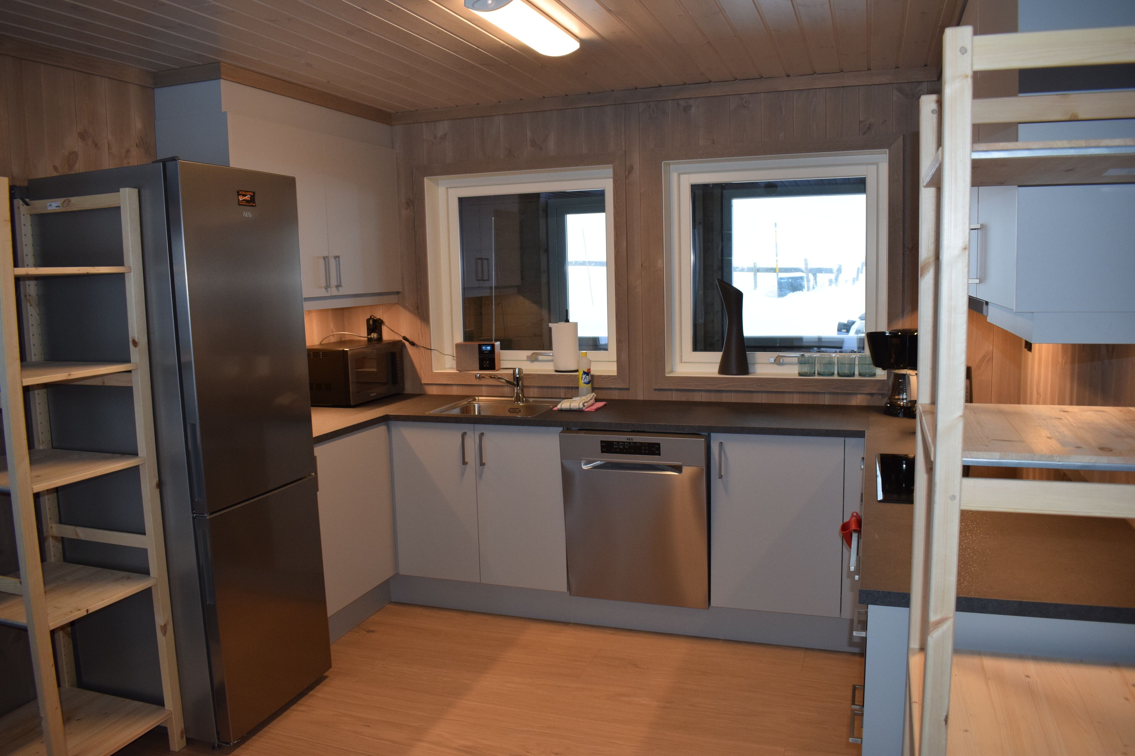 Una cocina moderna con electrodomésticos de acero inoxidable, armarios de madera y un ventanal que proporciona luz natural.