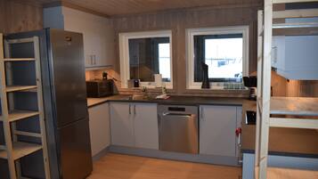 Una cocina moderna con electrodomésticos de acero inoxidable, armarios de madera y un ventanal que proporciona luz natural.