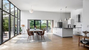 Una cocina moderna con comedor, ventanas amplias y vista a zonas verdes.