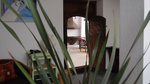 A room with a wooden door, a chair, and a small table. - Maison de Vacances a la Campagne Avec Piscine (ESSAOUIRA)