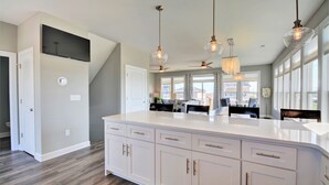 A spacious kitchen with a large island, pendant lights, and a ceiling fan. - Experience coastal views at Topsail Turvy, a spacious 4-bedroom home in North Topsail Beach. (North Topsail Beach)