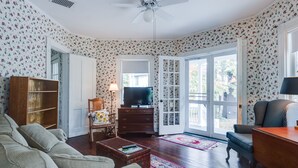 A living room with a sofa, a television, a wooden cabinet, and a patterned rug. - 12 Hurst - Chautauqua Charmer (Chautauqua)