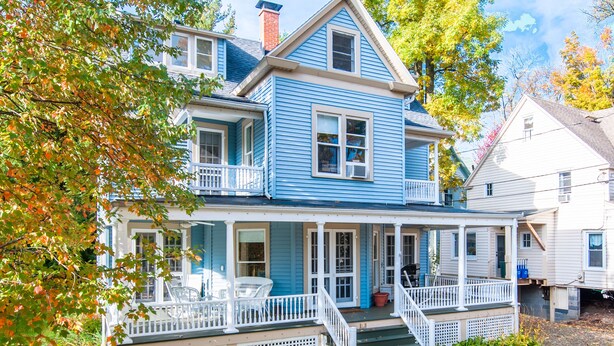 A two-story house with a porch, white railings, and a front door. - 12 Hurst - Chautauqua Charmer (Chautauqua)