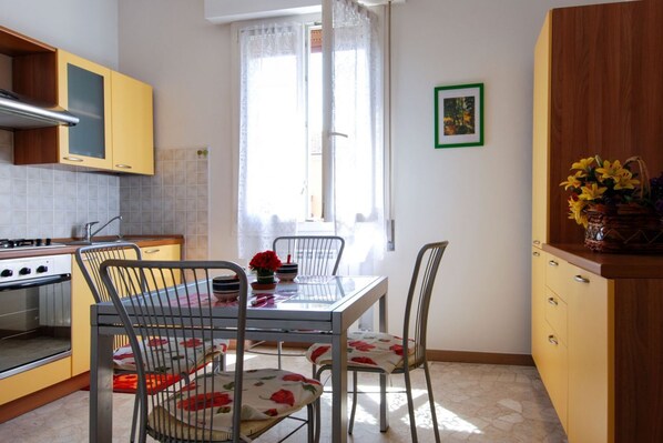 A kitchen with a dining table, chairs, and a stove.
