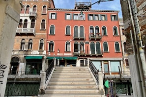 Una escalera que conduce a un edificio con varias ventanas y balcones.