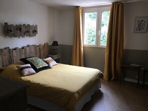Cozy retreat with a large bed, wooden headboard, and a bedside table with a lamp.