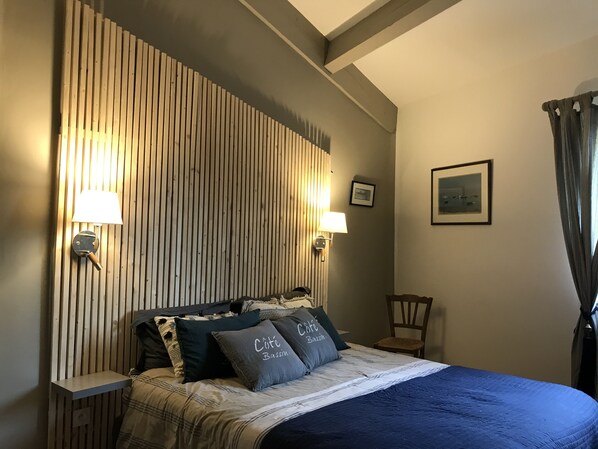 Cozy retreat with a bed, lamps, and a framed picture on the wall.