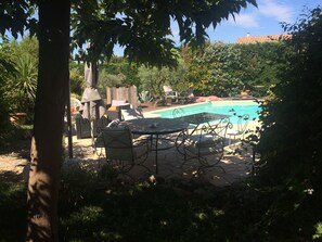 Relax by the serene pool surrounded by lush greenery and enjoy a meal or a moment of tranquility on the patio.