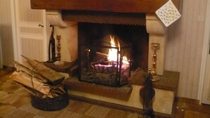 A fireplace with a mantel, logs, and a vase. - 6 bedroom Traditional Farmhouse, large pool, indoor & outdoor games areas. (Rives-d'Autise)