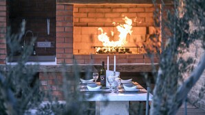 Une table dressée pour le dîner, avec une cheminée en briques en arrière-plan.