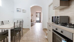 Una cucina moderna con zona pranzo, dotata di fornello, forno e tavolo con sedie.