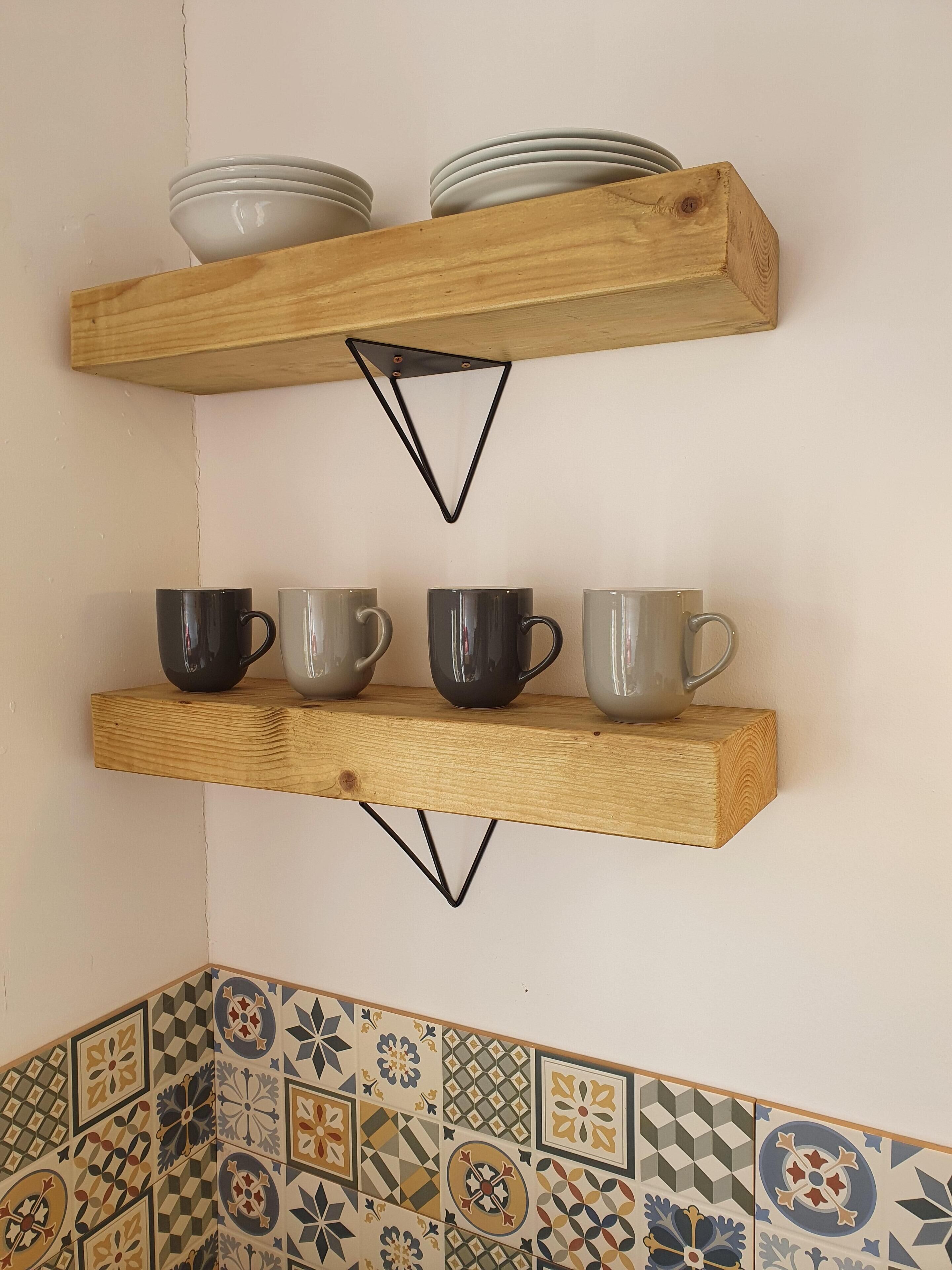 Two wooden shelves mounted on a wall, each holding bowls and mugs.