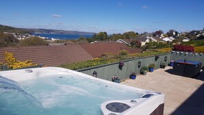 Ein Whirlpool mit Blick auf das Meer und Häuser im Hintergrund.
