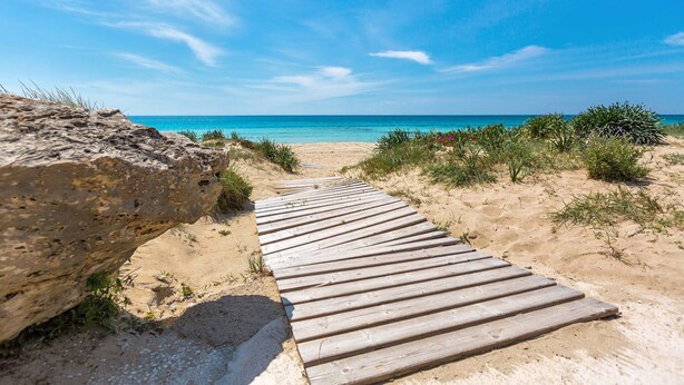A wooden pathway leading to a sandy beach with clear blue water in the background. - 1817 Villetta Ginetta (Maruggio)
